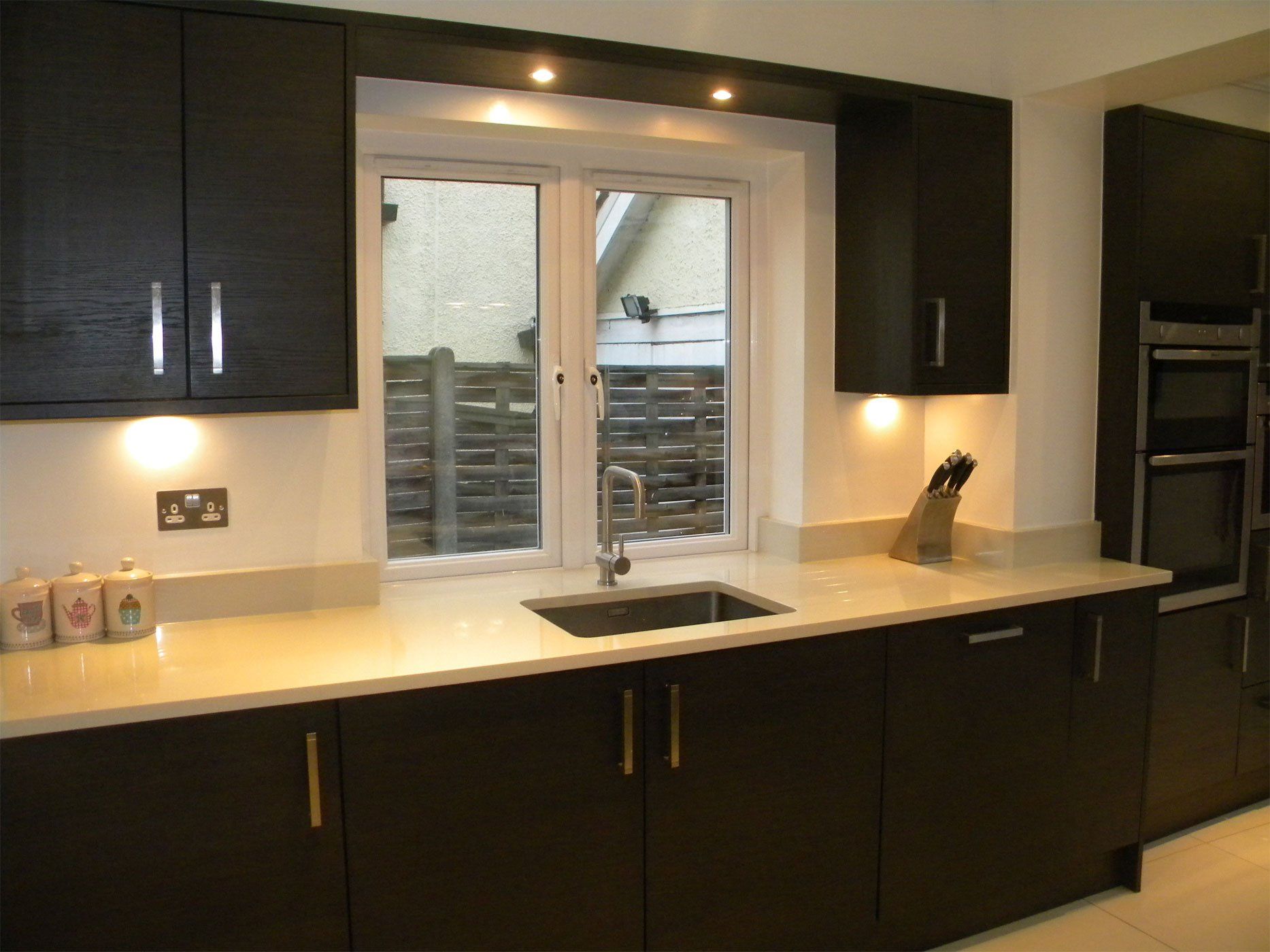 black kitchen with white countertops.