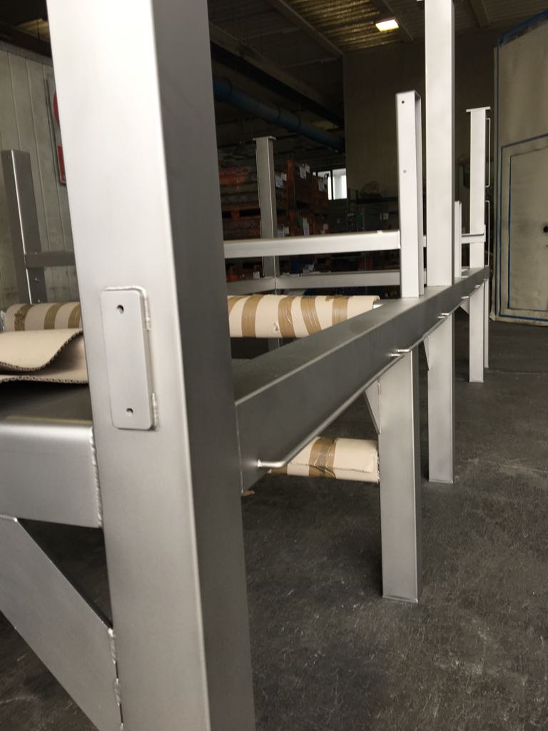 Una struttura metallica è appoggiata sul pavimento di un magazzino.