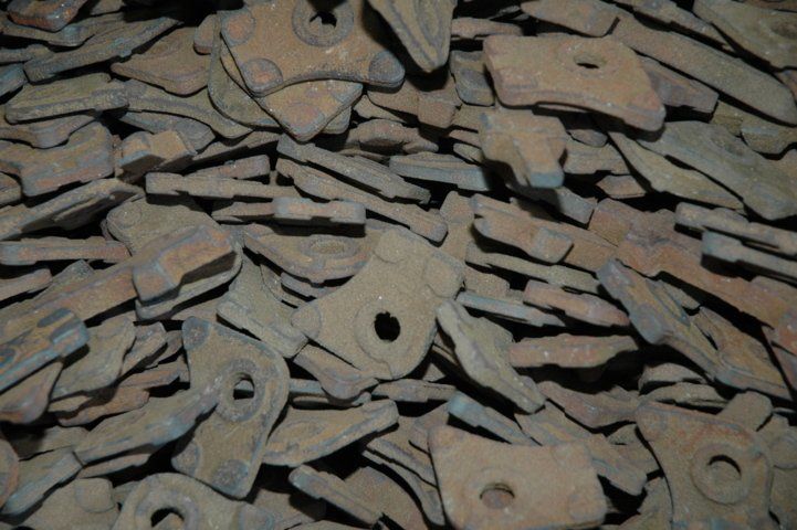 Un mucchio di pezzi di metallo arrugginiti con dei buchi