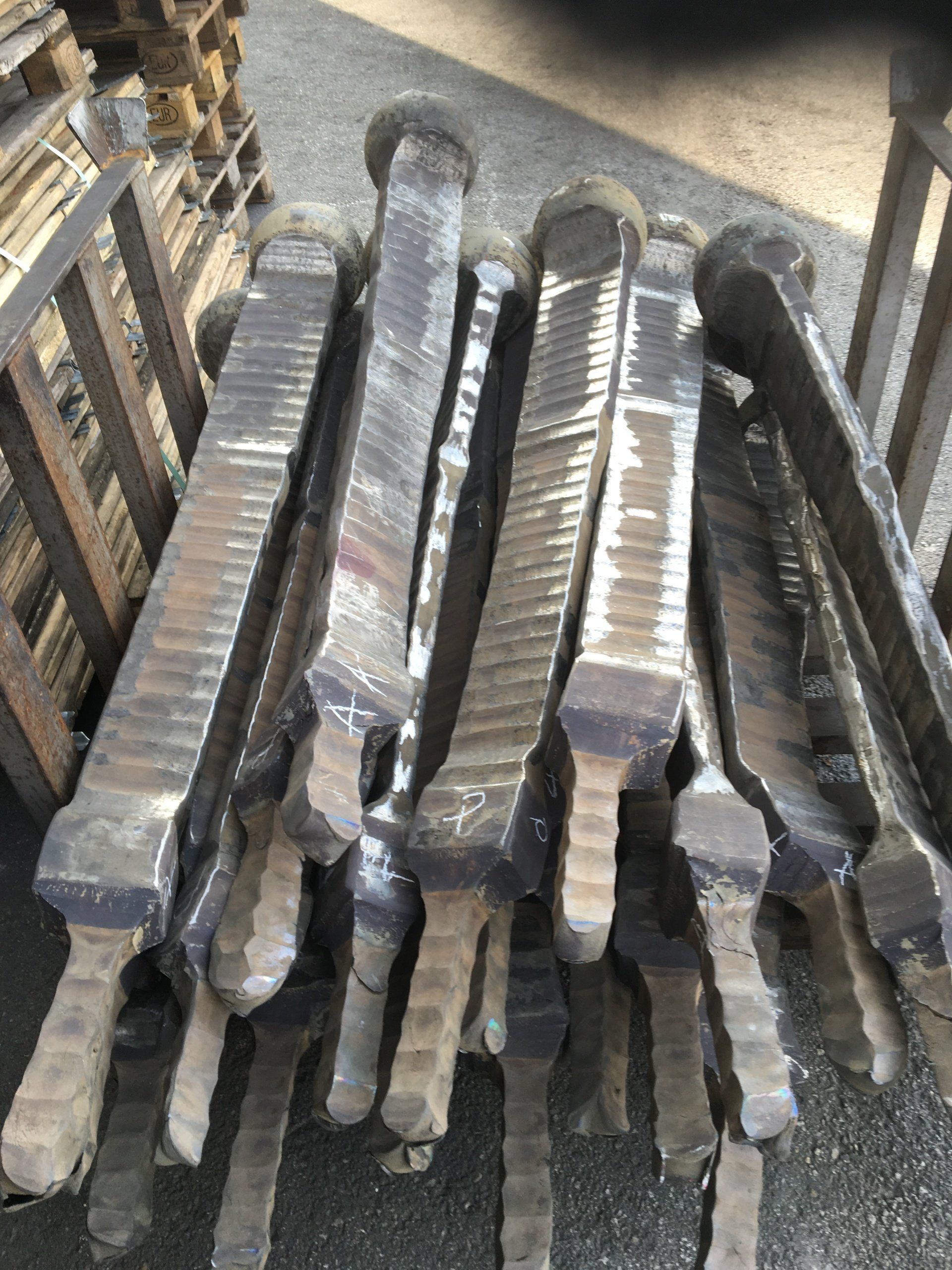 Un mucchio di pezzi di metallo avvolti nella plastica sono impilati uno sopra l'altro.