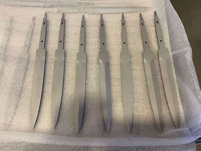 Un mucchio di coltelli sono allineati su un panno bianco