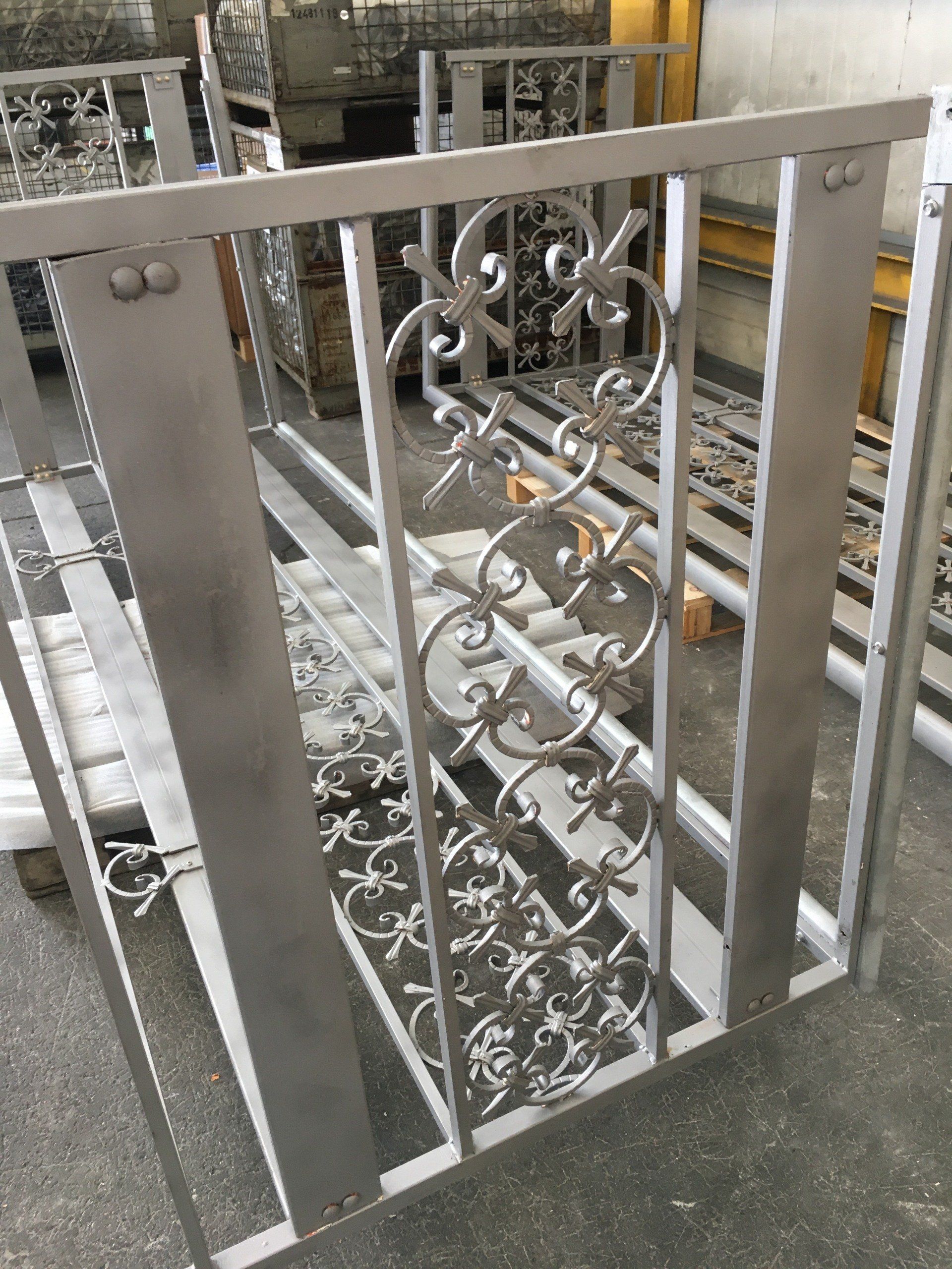 Una ringhiera in acciaio inossidabile è appoggiata a terra in una fabbrica.