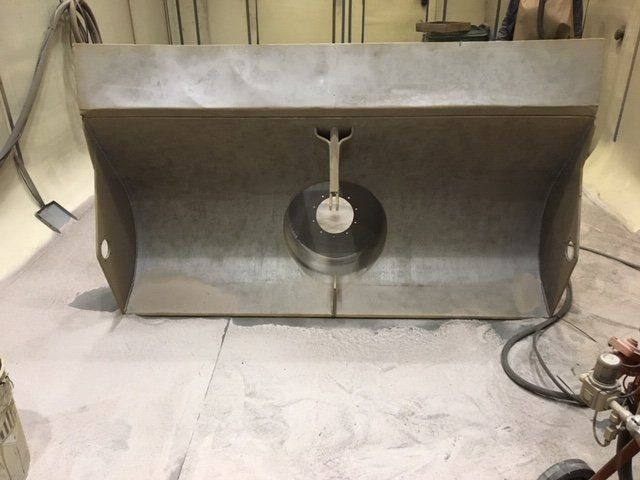 Una cappa in acciaio inossidabile è appoggiata sul pavimento in una stanza