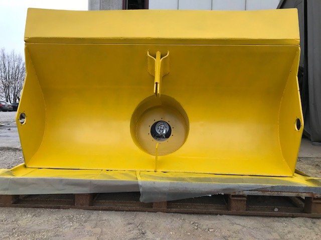 Un grande oggetto giallo è appoggiato su un pallet di legno.