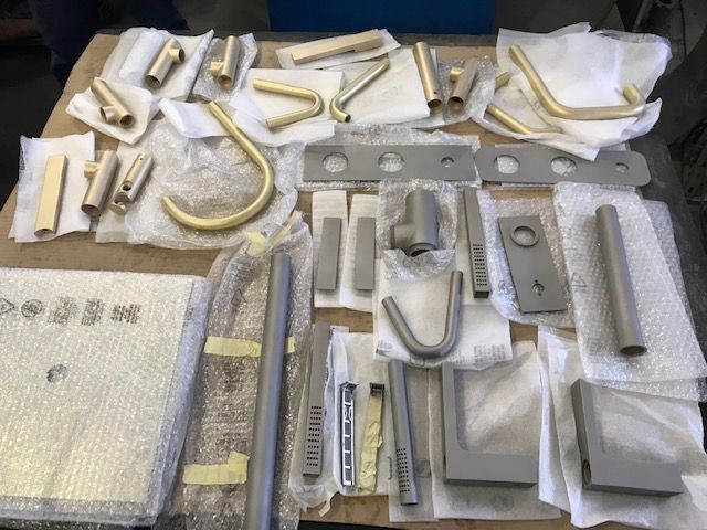 Un tavolo con un mucchio di parti metalliche sopra