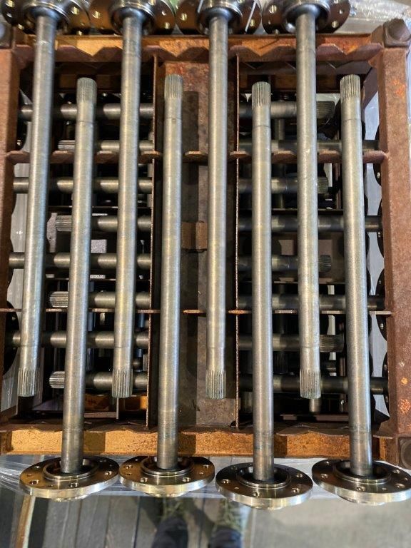 Un mucchio di tubi metallici sono accatastati uno sopra l'altro in una scatola.