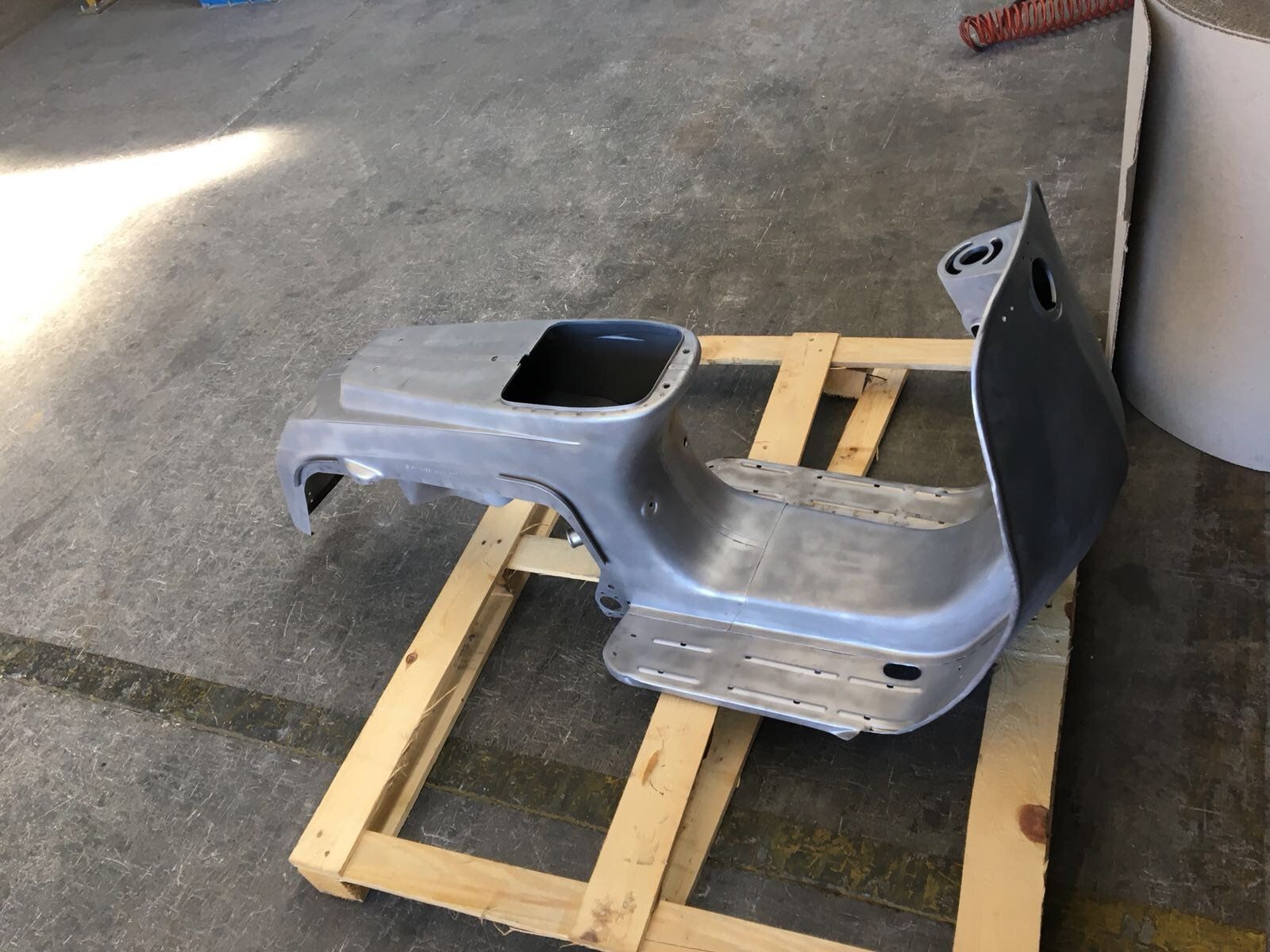 Un pezzo di metallo è appoggiato su un pallet di legno.