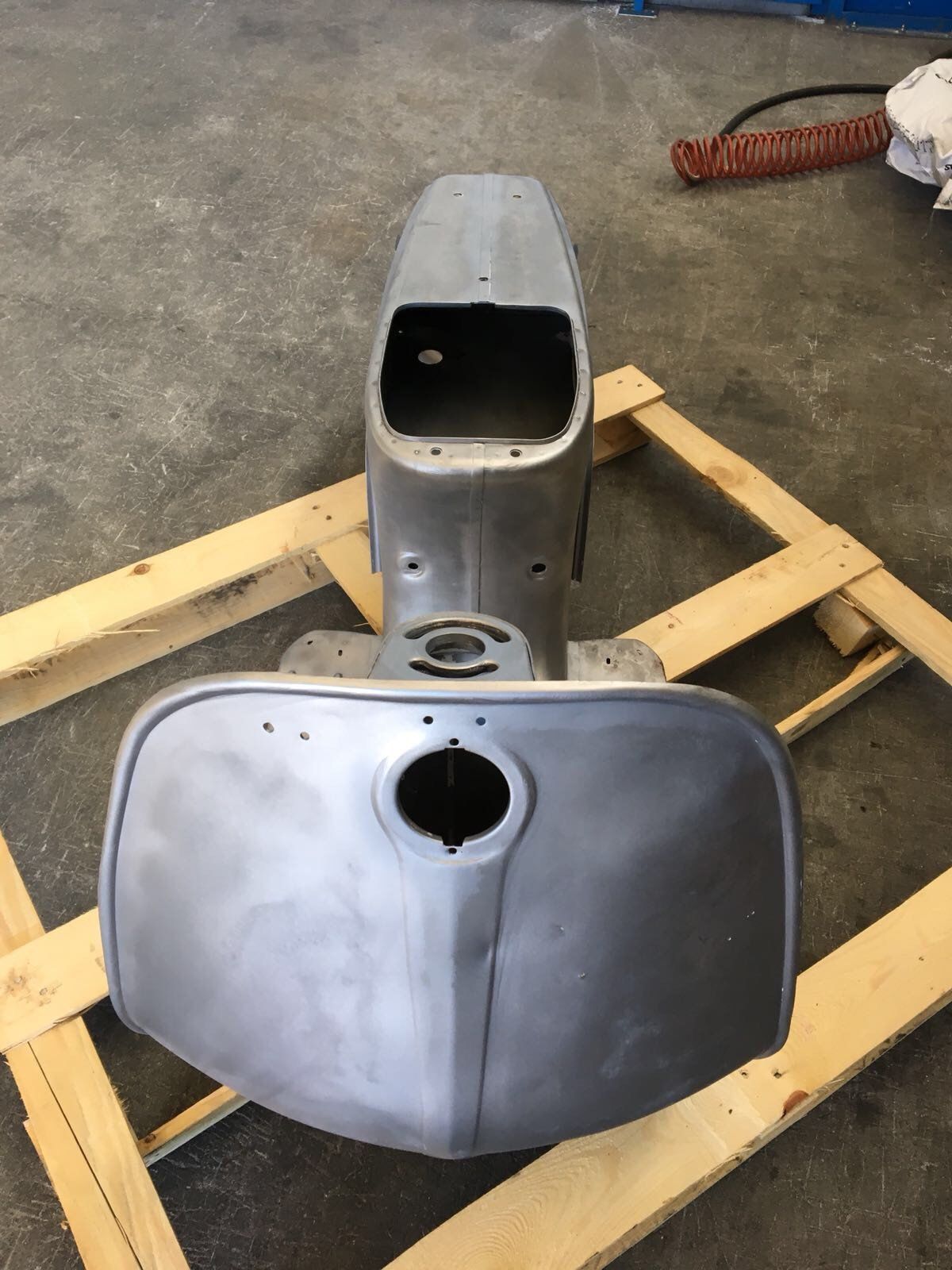 Un oggetto metallico è appoggiato su un pallet di legno.