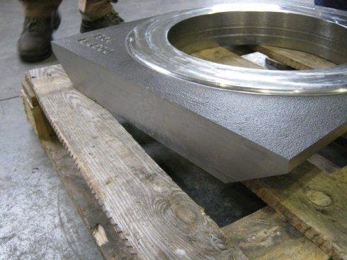 Un pezzo di metallo è appoggiato su un pallet di legno.