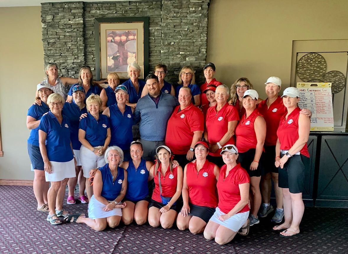 Group of people in red and blue golf attire posing together indoors.