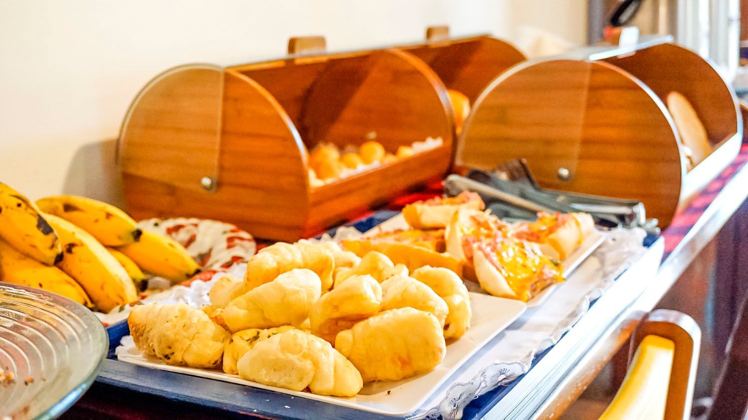 Uma mesa de madeira coberta com caixas de pão e um bolo.