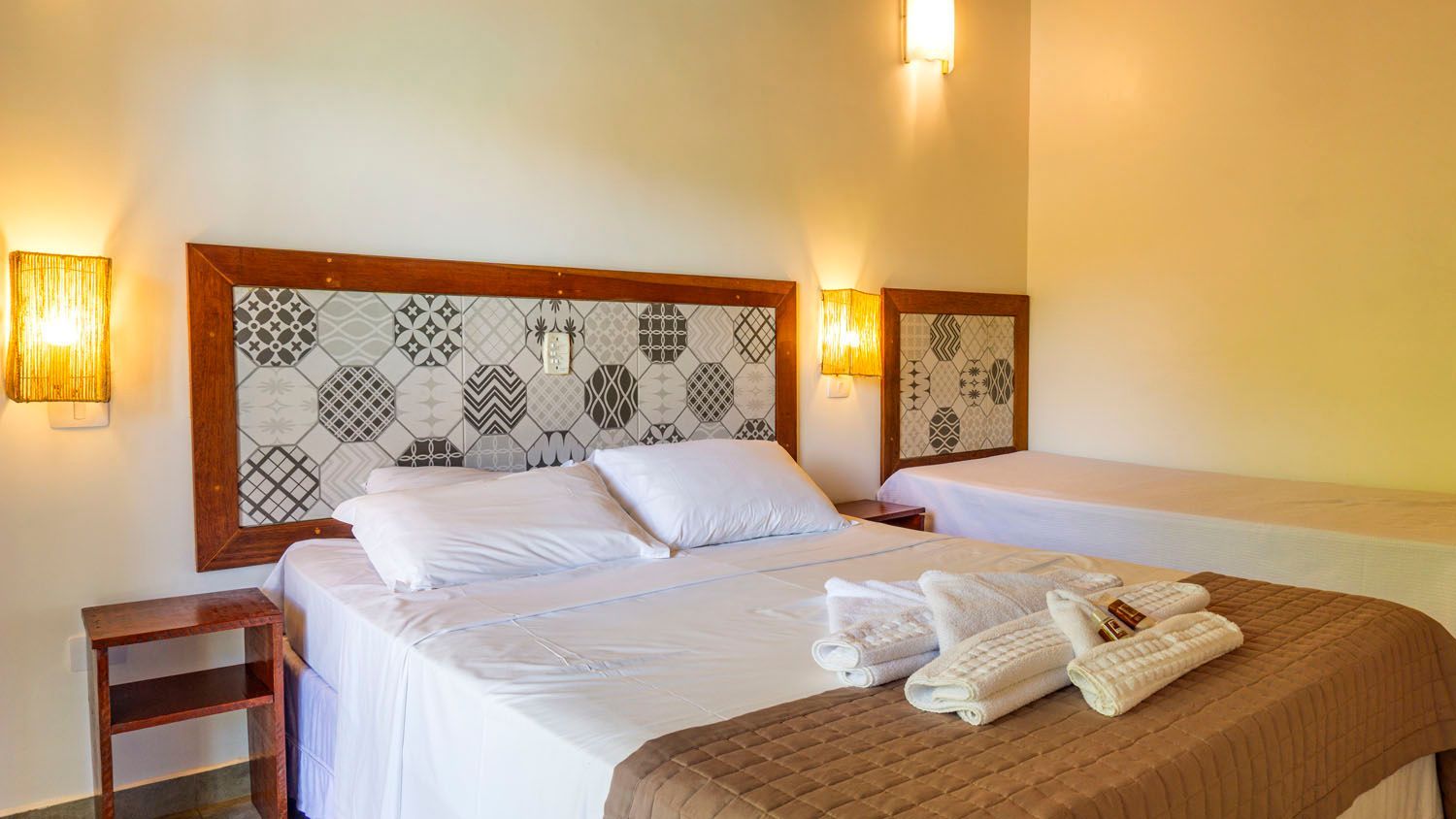 Um quarto de hotel com uma cama king size e duas camas de solteiro.