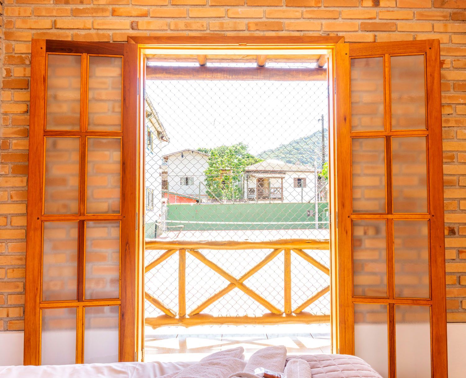 Um quarto com uma parede de tijolos e uma janela de madeira