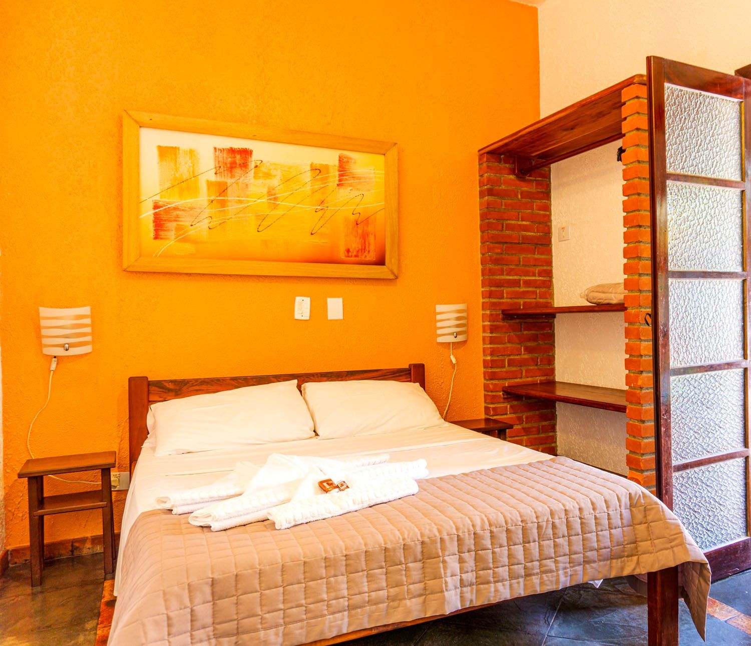 Um quarto com uma cama e uma pintura na parede