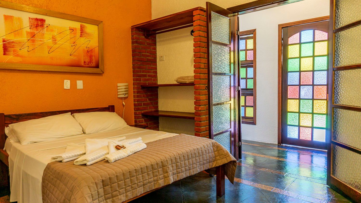 Um quarto com uma cama e um vitral.