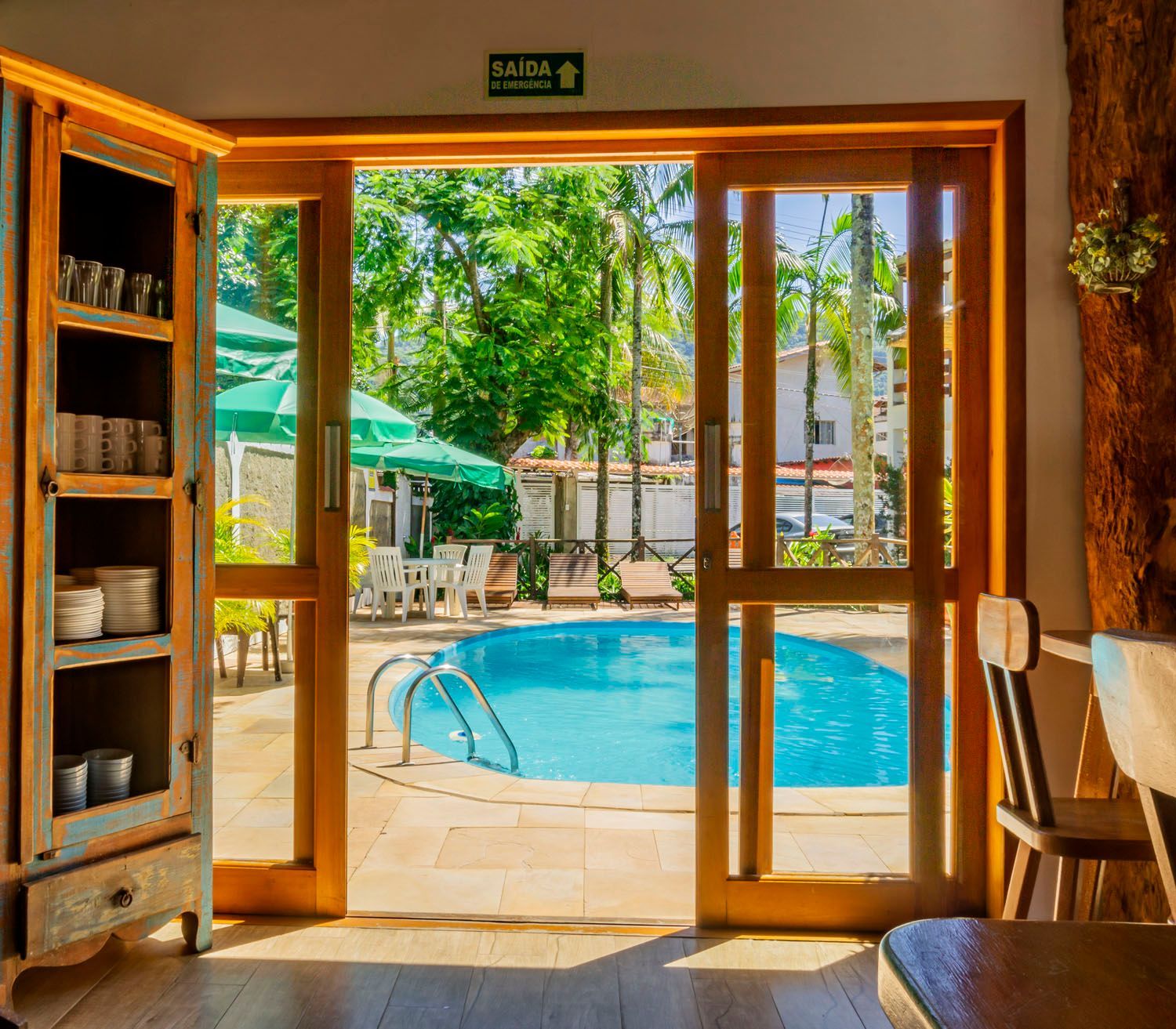 Uma sala com portas de vidro deslizantes que levam a uma piscina.