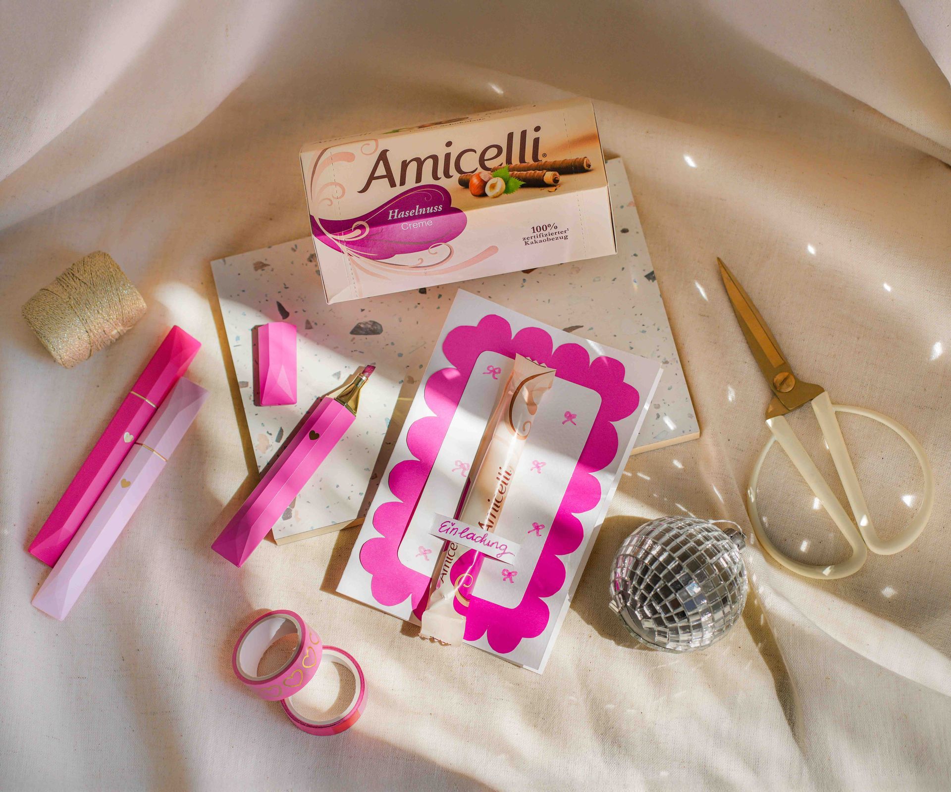 A box of amicielli sits on a table next to a vase of paper flowers