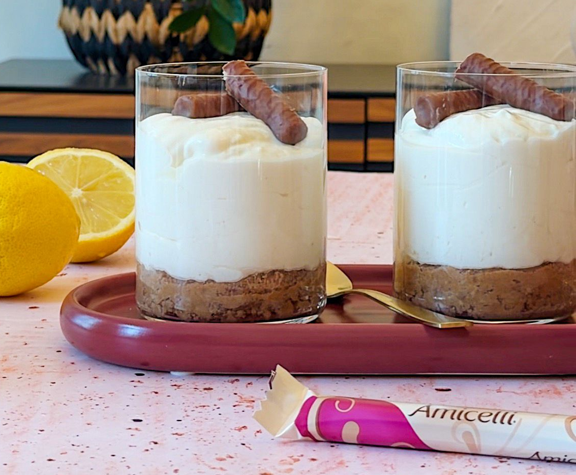 A box of amicielli sits on a table next to a vase of paper flowers