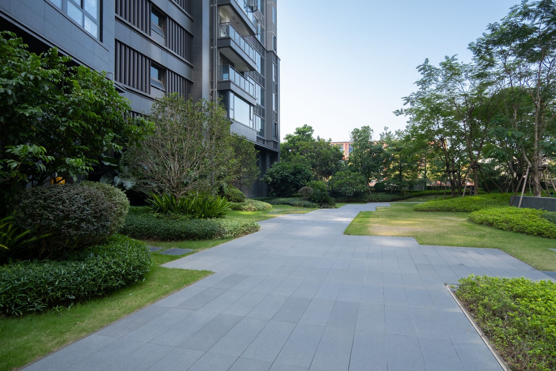 Un grand bâtiment avec beaucoup de fenêtres et d'arbres devant lui.
