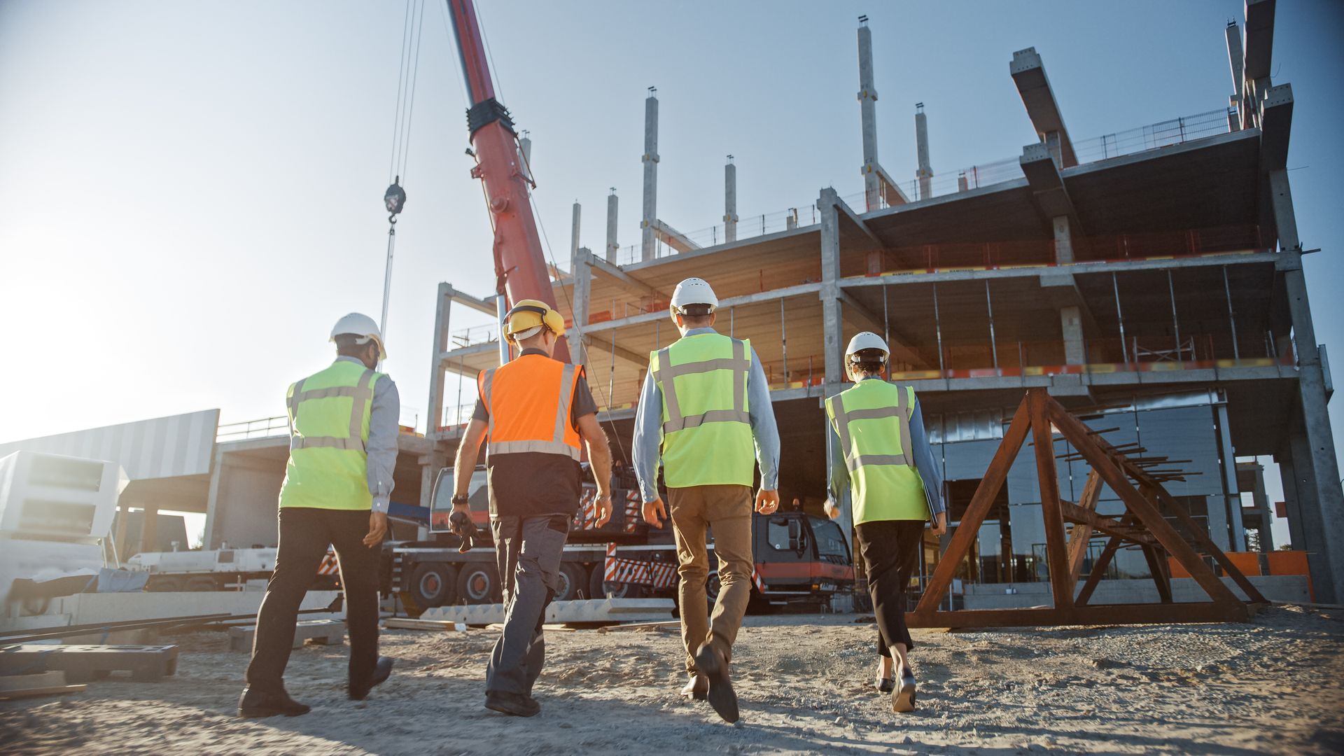 A group of construction workers are walking on a construction site.