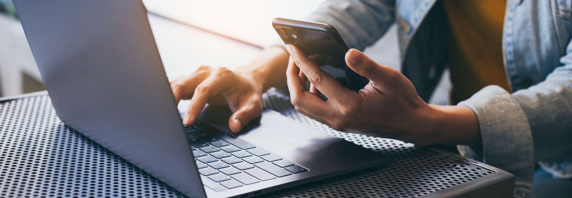 A person is using a laptop and a cell phone at the same time.
