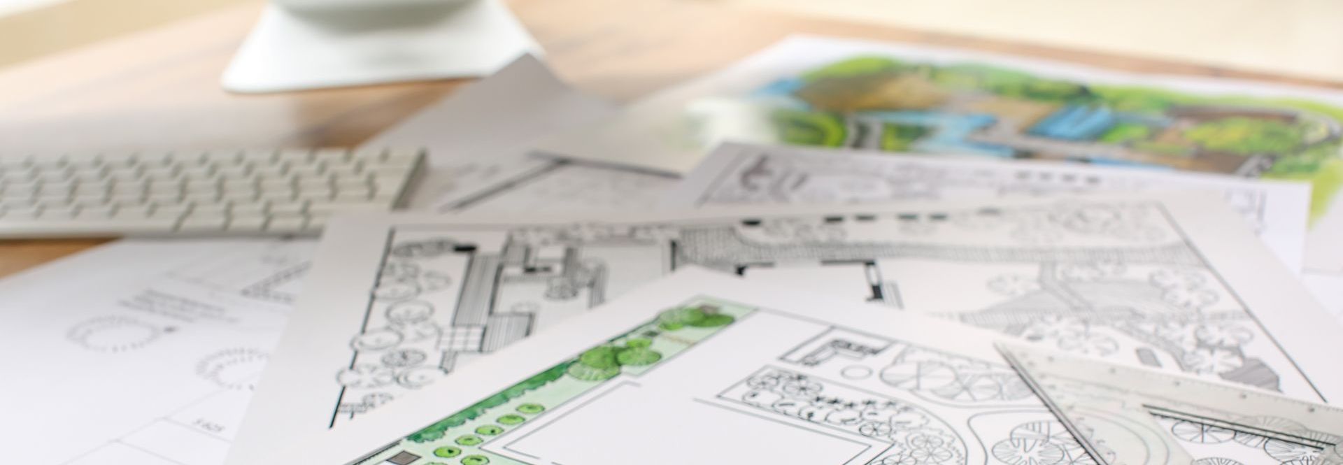 Un tas de dessins sont posés sur une table en bois.