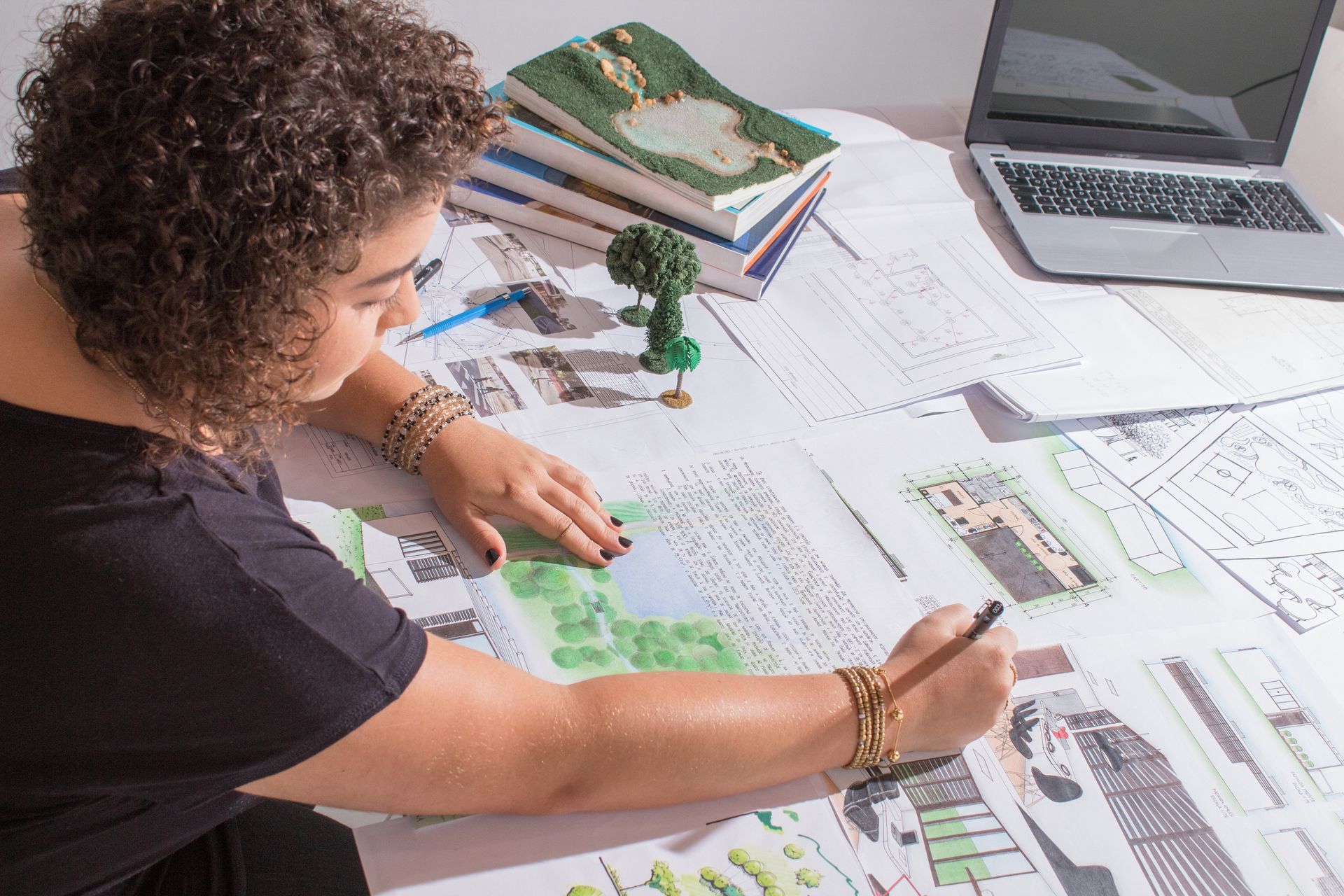 Une femme est assise à une table et dessine sur une feuille de papier.