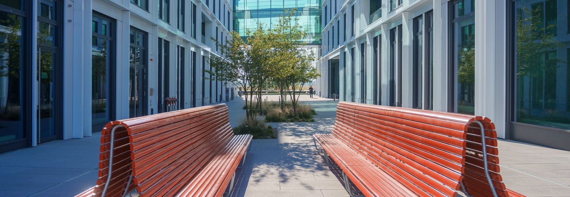 Deux bancs rouges sont assis l'un à côté de l'autre devant un bâtiment.