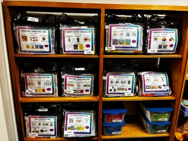 Wooden classroom cubbies filled with labeled learning bins and baskets of supplies