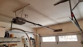 Garage ceiling with a black garage door opener and the tracks for the door.