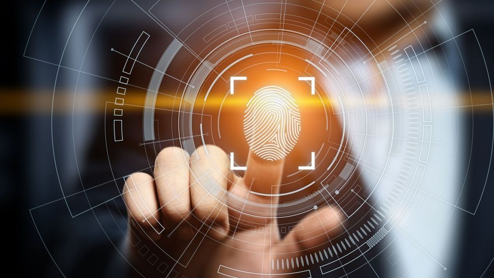 Fingerprint scan authentication, person placing finger on a digital interface for security access.