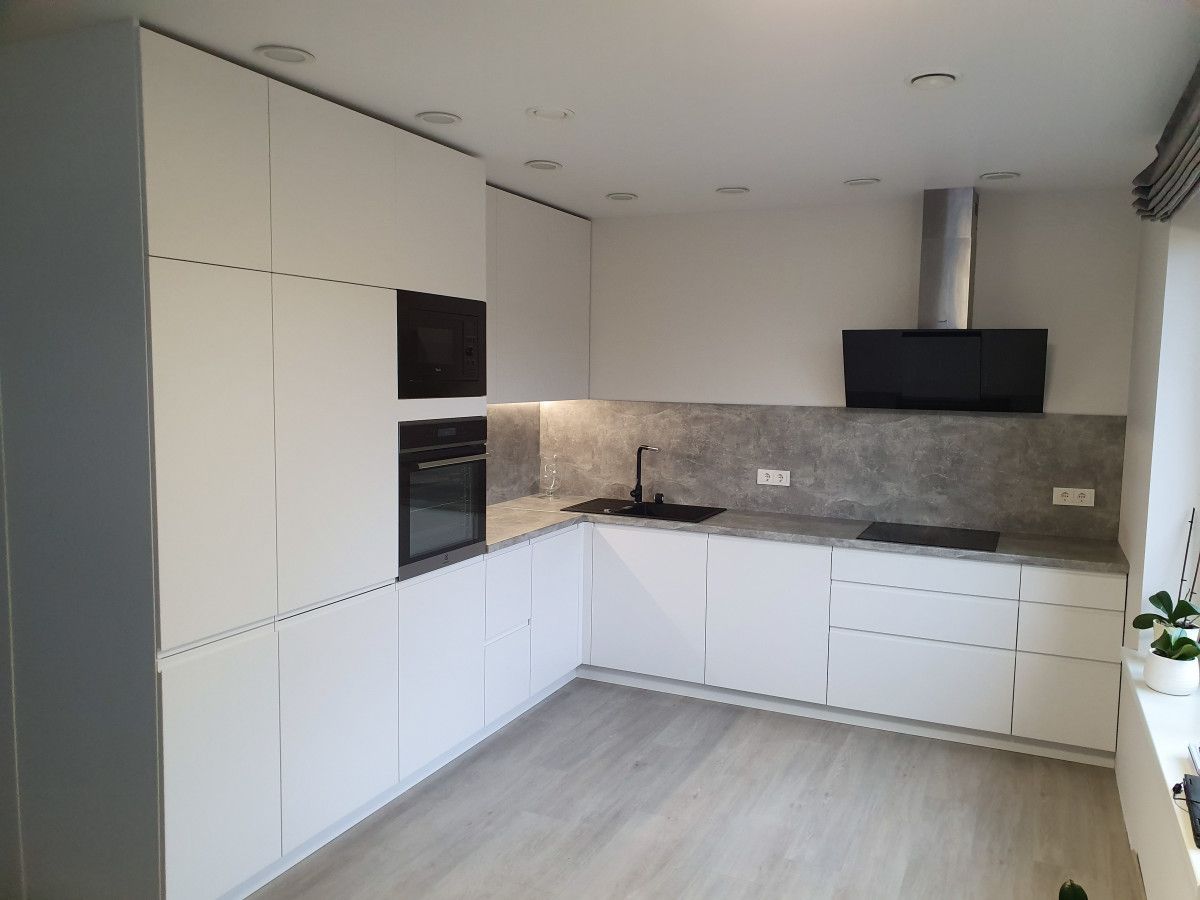 Virtuvė su baltomis spintelėmis ir nerūdijančio plieno prietaisais