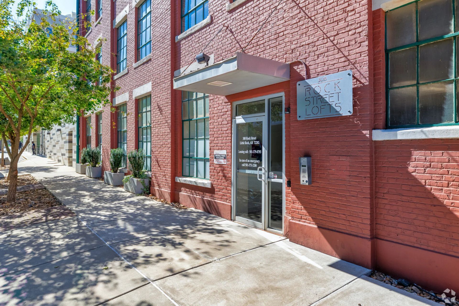 Brick building with glass door entrance and sidewalk.