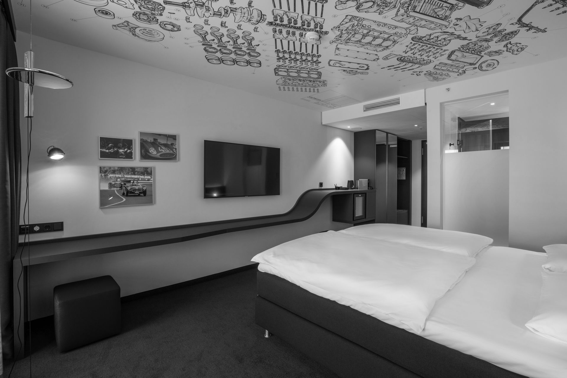 Modernes Hotelzimmer mit großem Bett, Spiegelwand und Balkontüren mit Vorhängen.