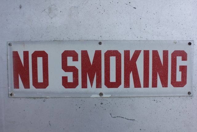 Rotes „RAUCHEN VERBOTEN“-Schild an einer hellen Wand