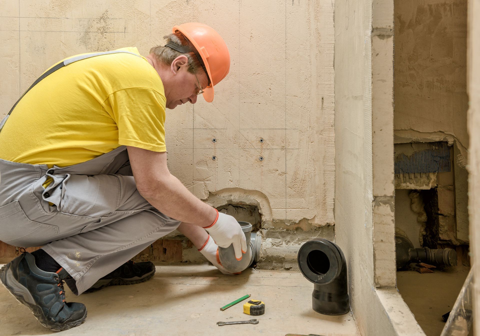 A man is working on a pipe in a bathroom A man is working on a pipe in a bathroom