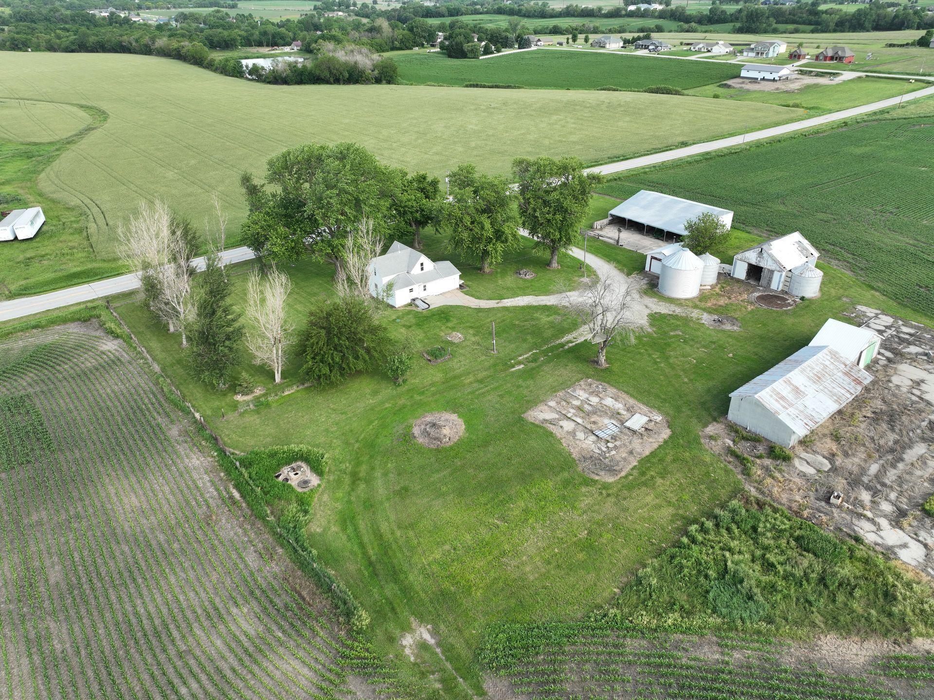 An aerial view of a farm surrounded by fields and trees
