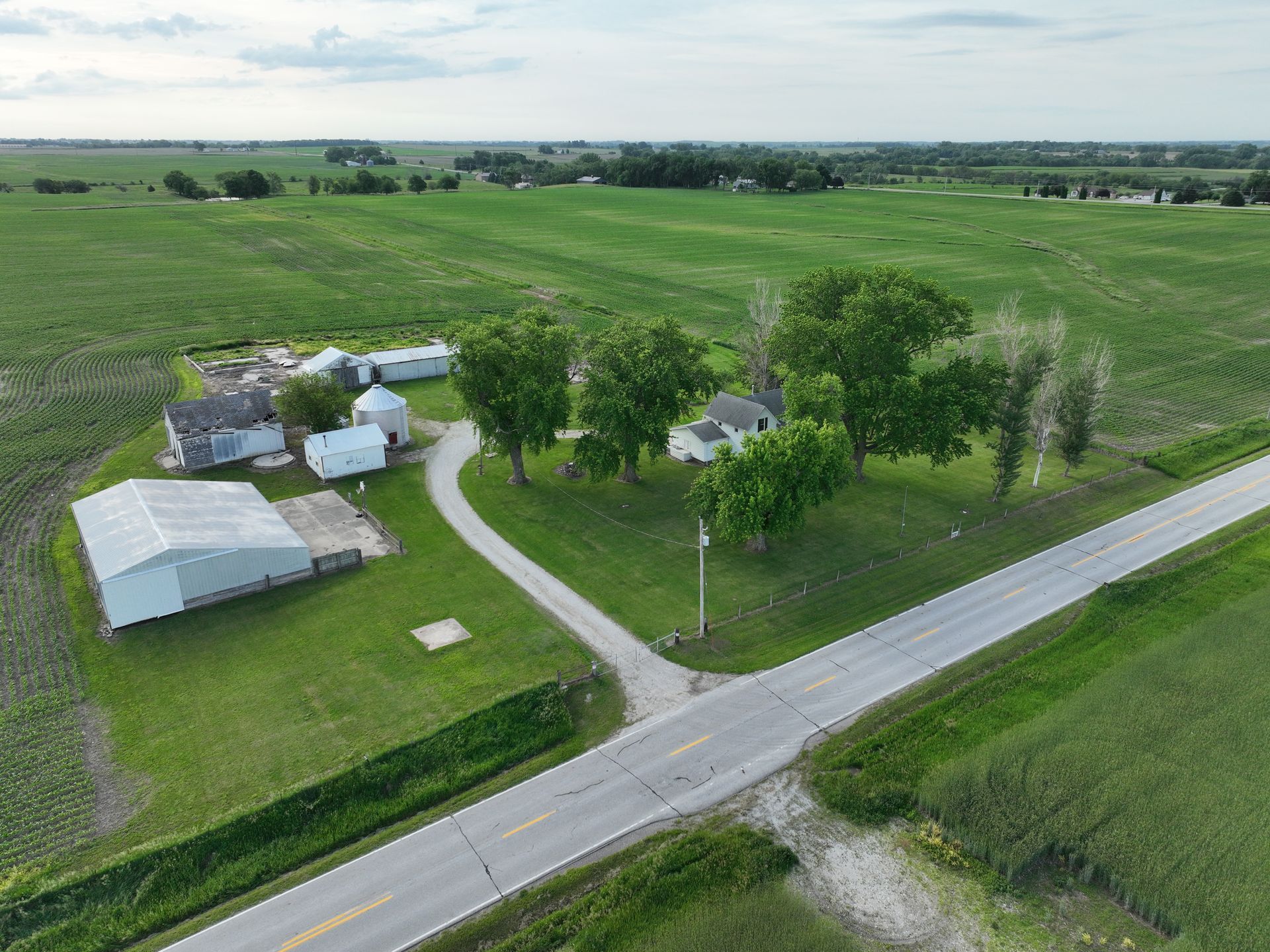An aerial view of a farm with a road going through it