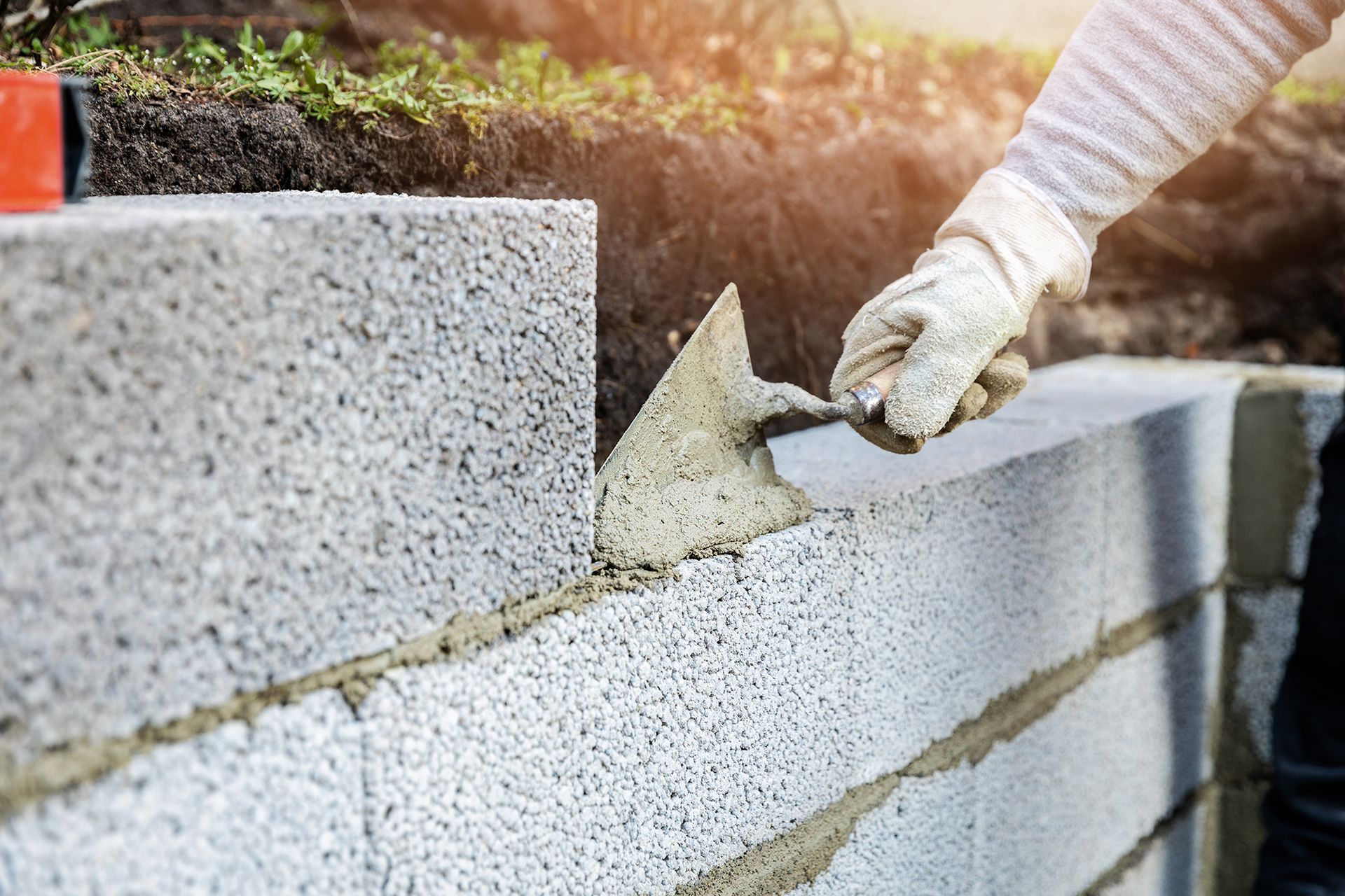 Man Installing Brick and Building a Brick Wall — Lincoln Park, MI — Dix Block and Supply Company Inc.