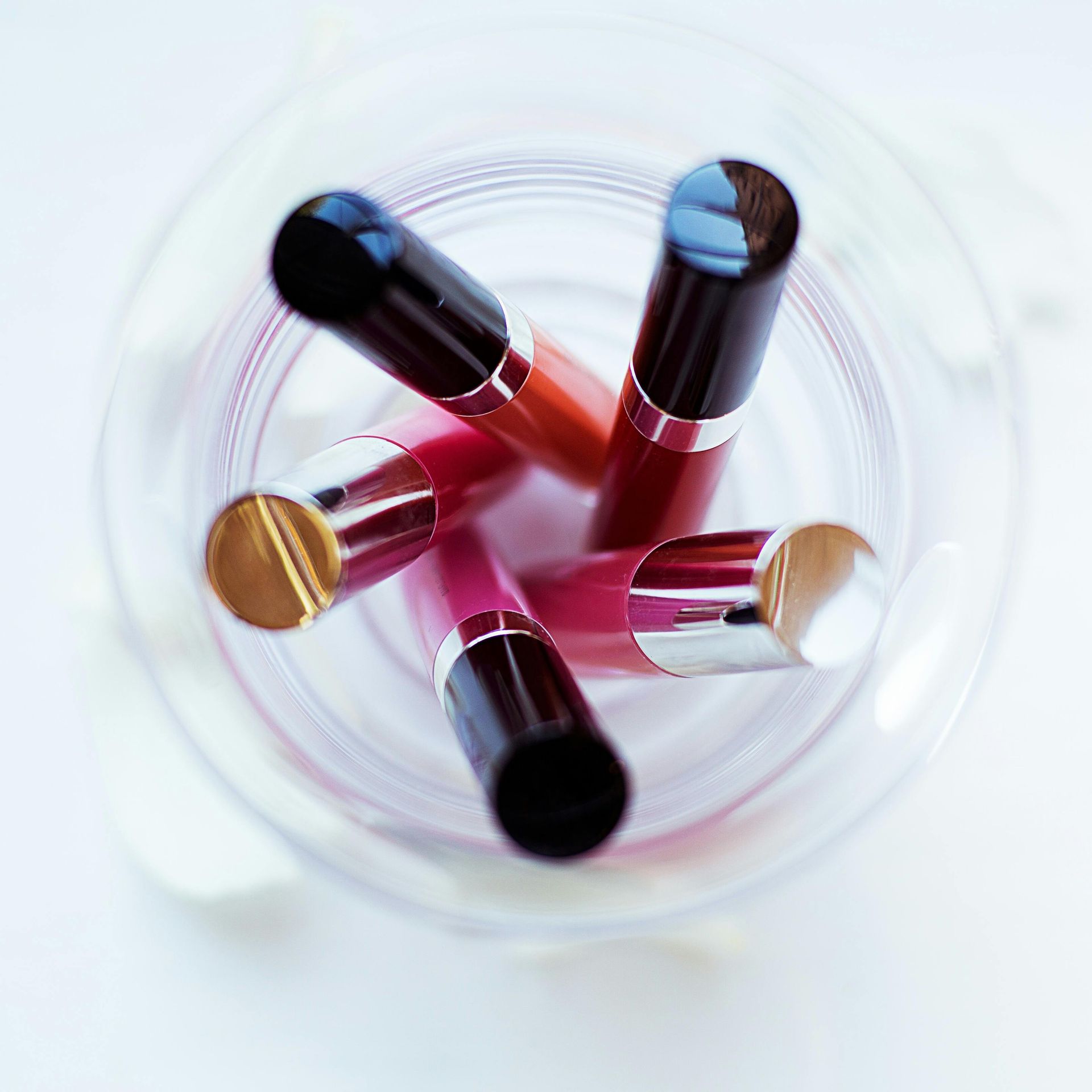 A glass bowl filled with lipsticks of different colors