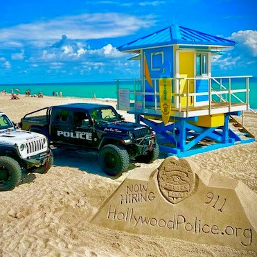 A police officer is talking on a walkie talkie next to a car.