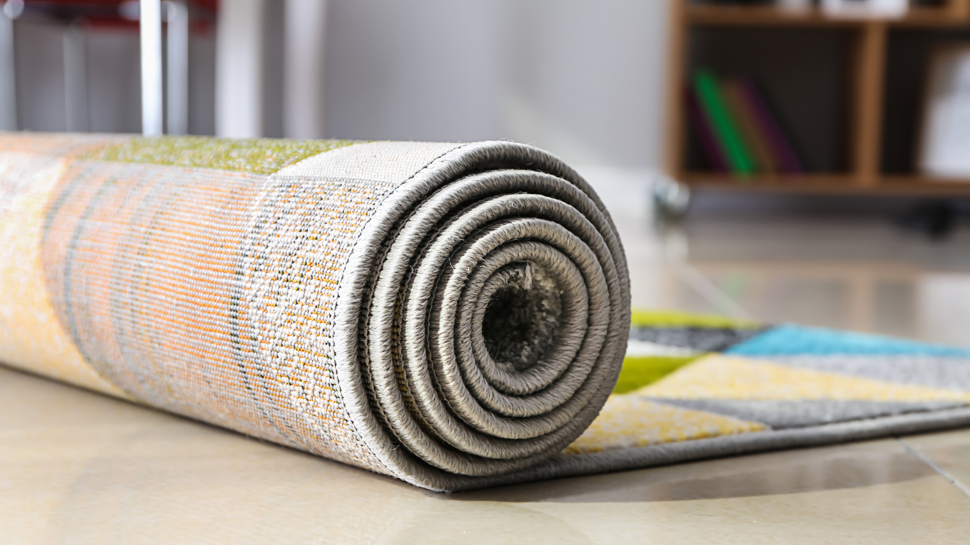 A rug is rolled up on the floor in a living room.