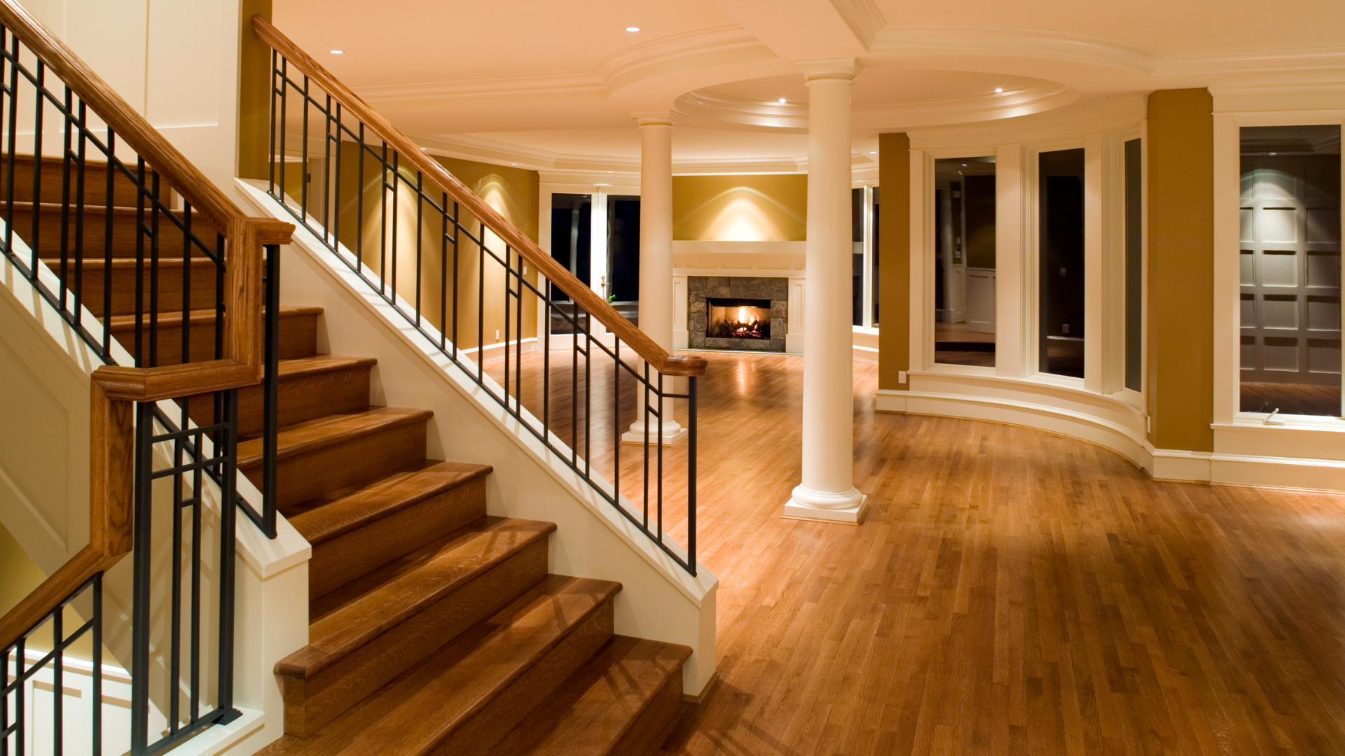 A staircase in a basement with hardwood floors and a fireplace