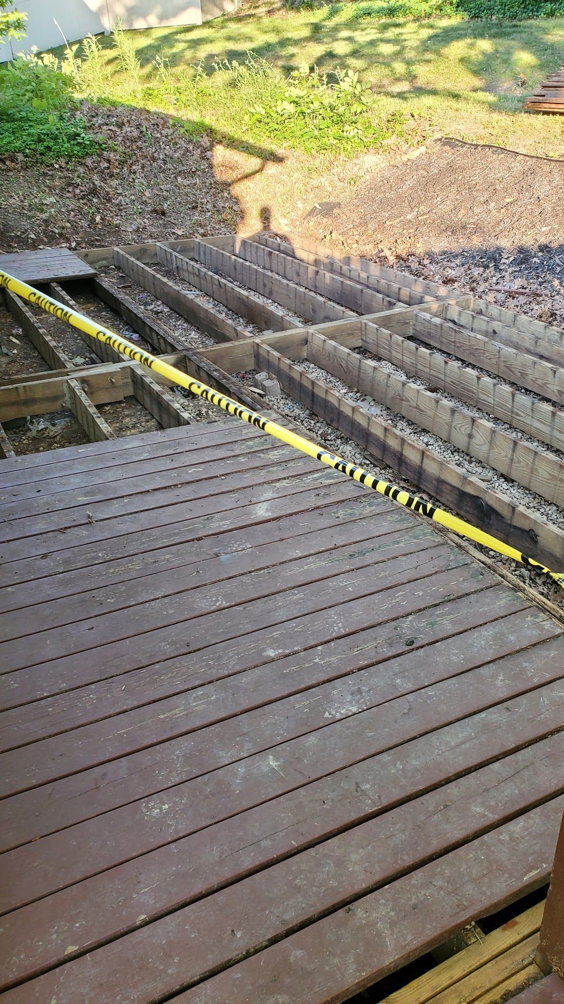 a wooden deck with a yellow caution tape around it .