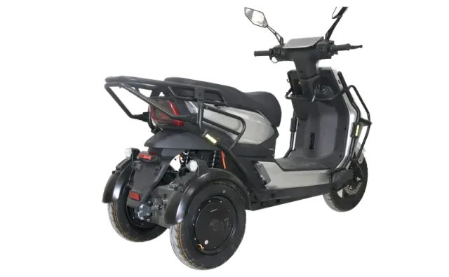 Zilverkleurige driewielige elektrische scooter met zwarte banden en zadel, gezien vanuit een vooraanzicht rechts.