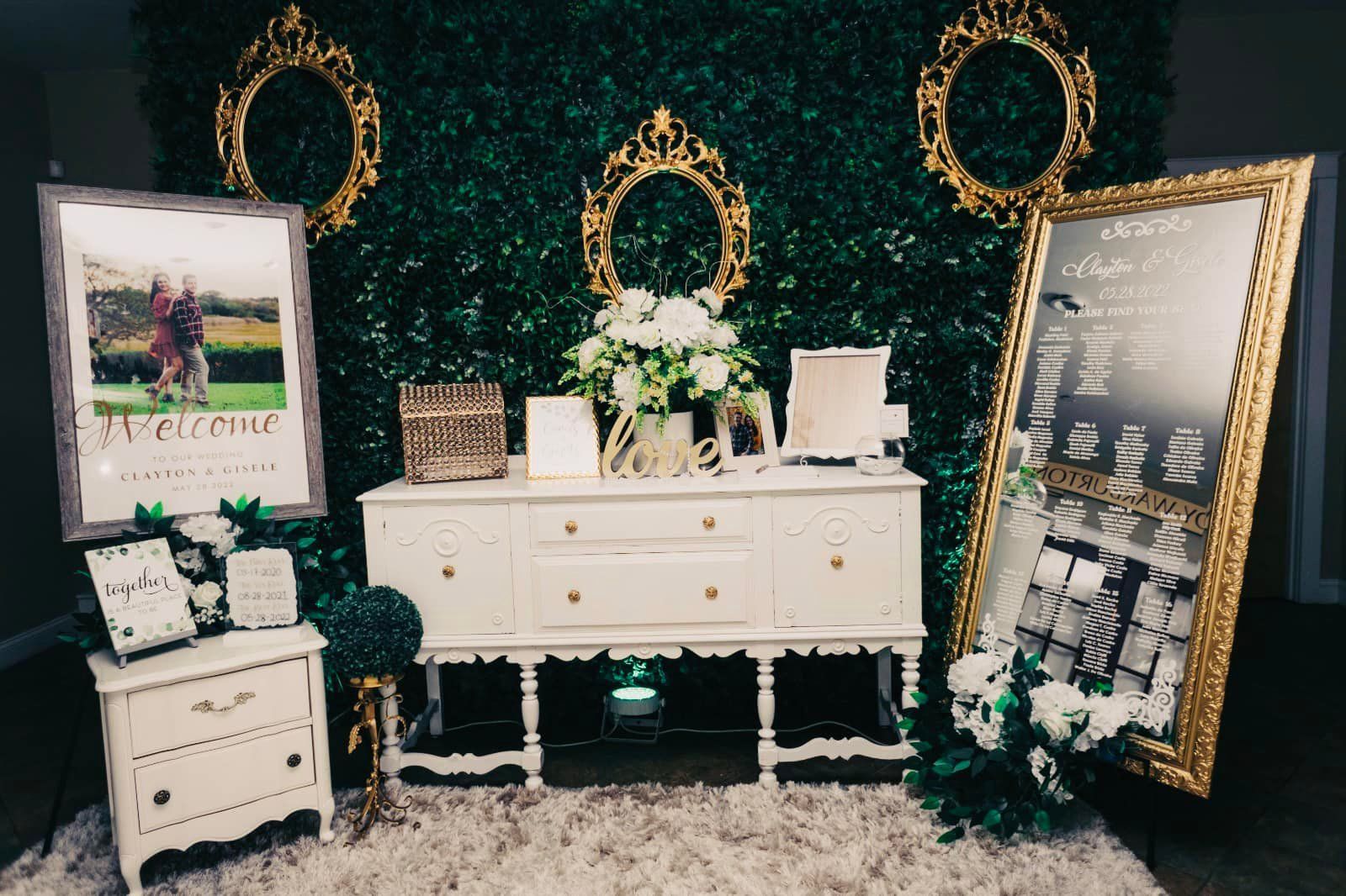 A white dresser is sitting in front of a green wall.