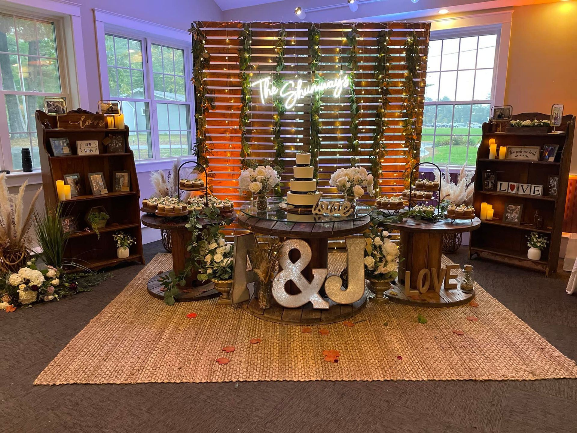 There is a table with a cake on it in the middle of the room.