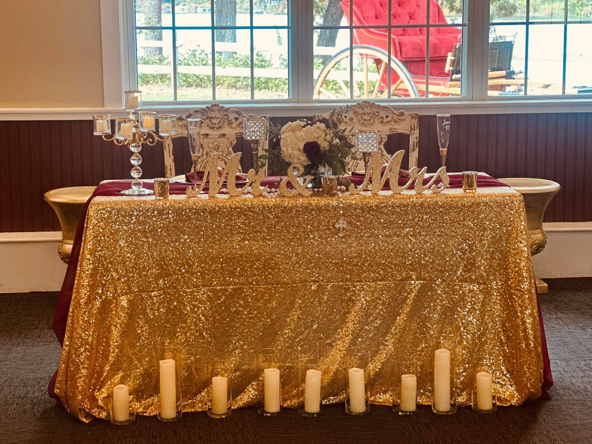 A table with a gold tablecloth and candles on it.