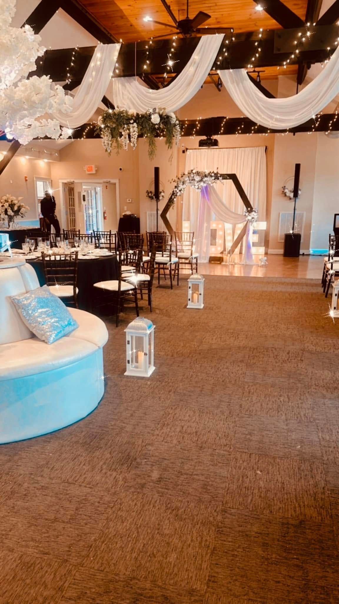 A large room decorated for a wedding reception with tables and chairs.