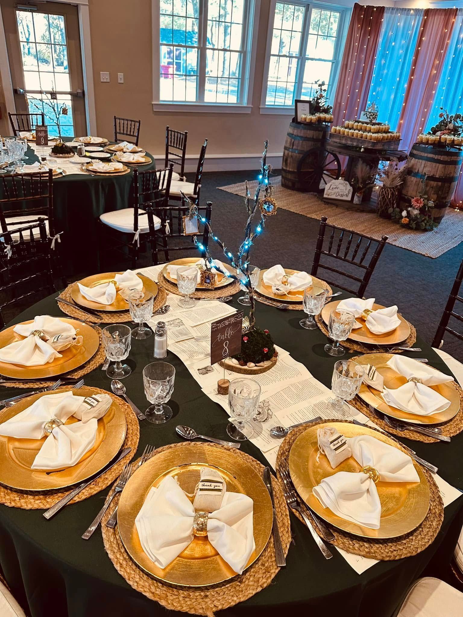 A table set for a wedding reception with gold plates and napkins.